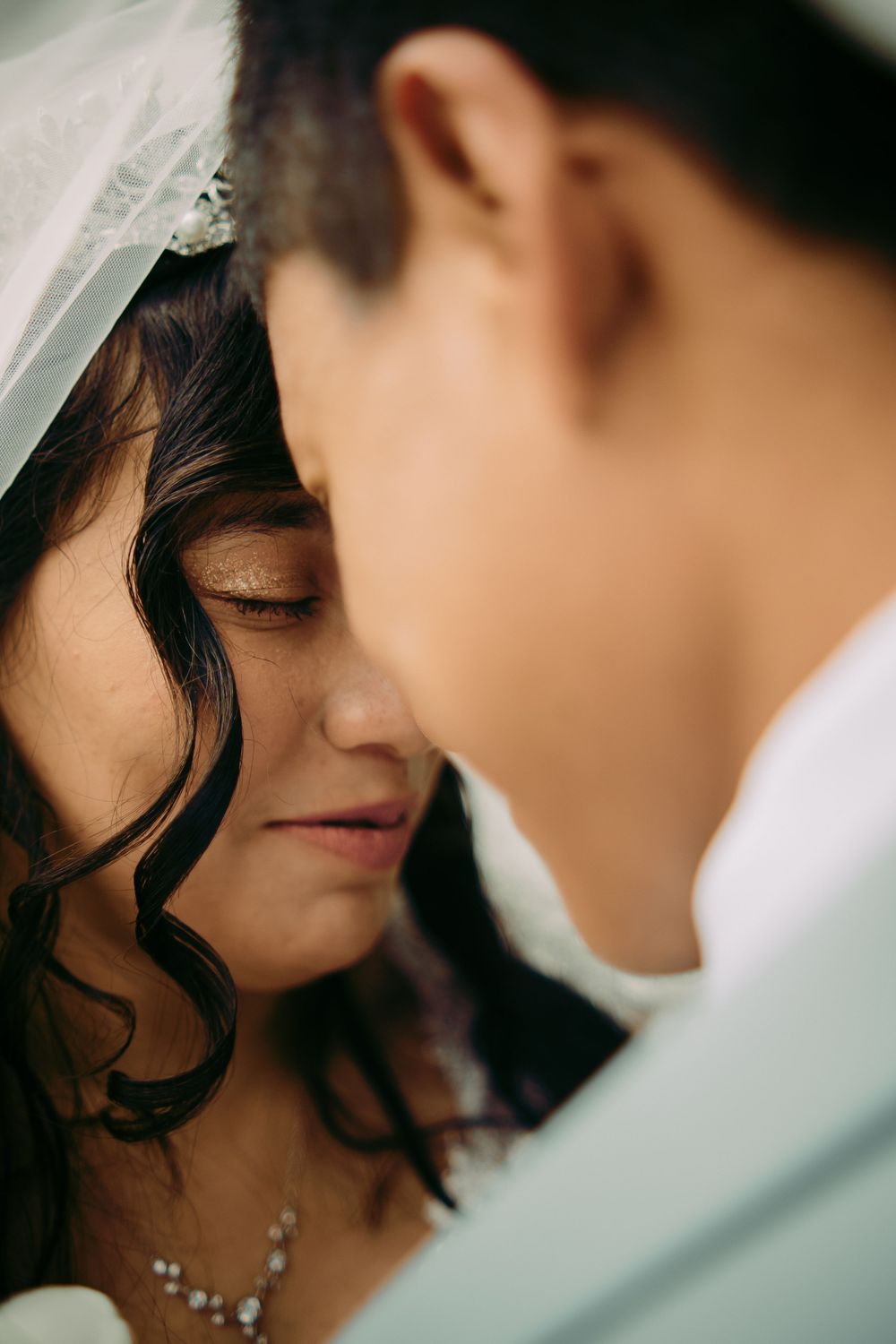 Close up couple portrait under the bride veil