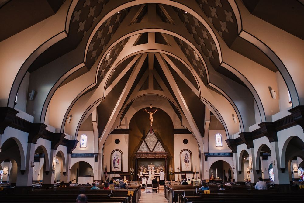 A panoramic view of an elegant church interior with vaulted ceilings and gothic arches in warm lighting.
